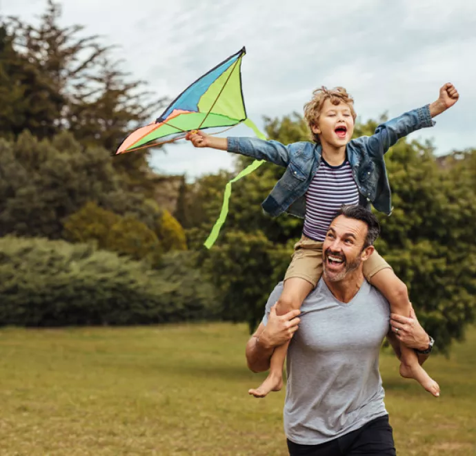 father and son flying kite at a park