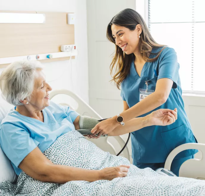 Nurse taking elderly woman blood pressure