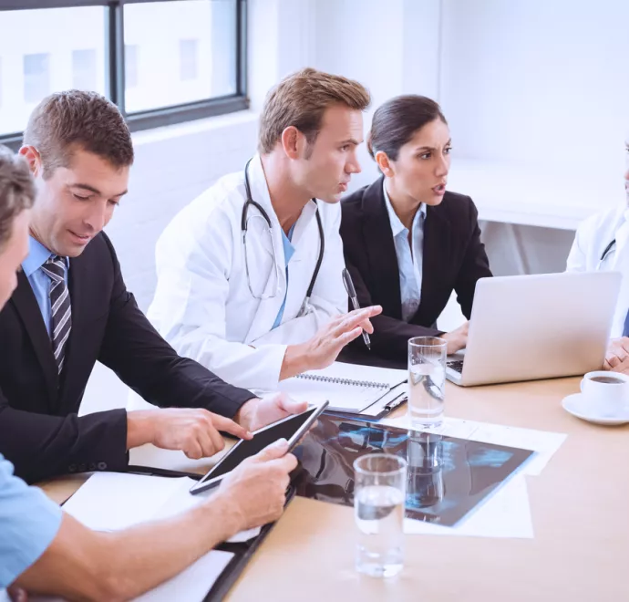 doctors and execs talking at table