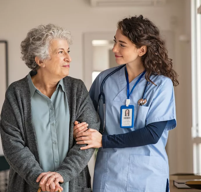 Nurse walking elderly woman